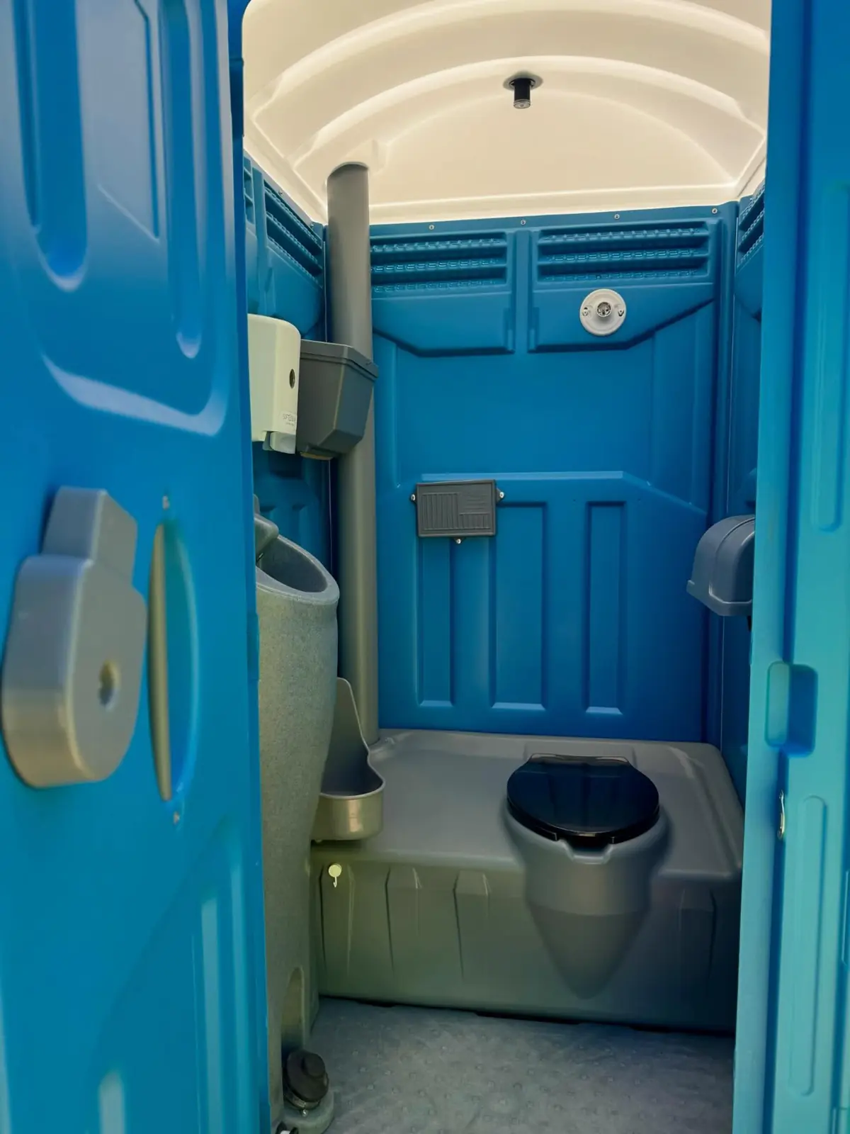 Inside a standard porta potty with two tissue holders, ready after service