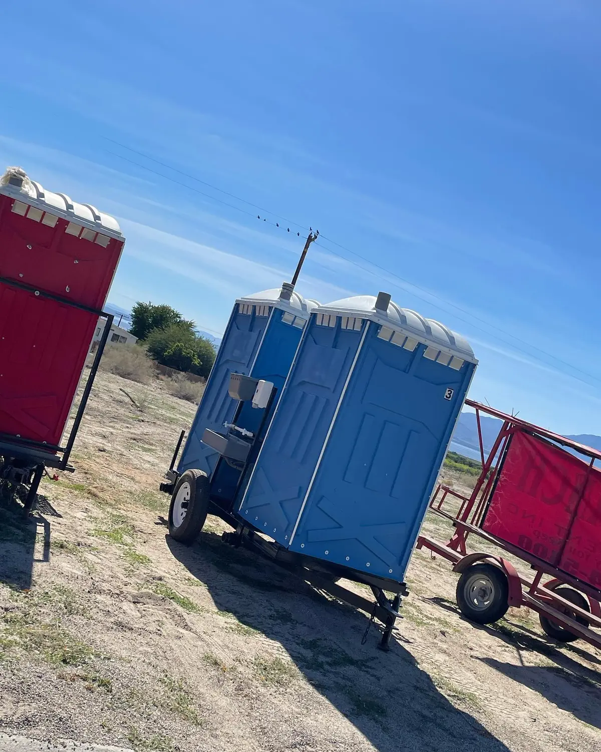 Side view of a towable porta potty trailer used by crews that move between sites